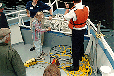 photo of crew and passengers inspecting a crab pot